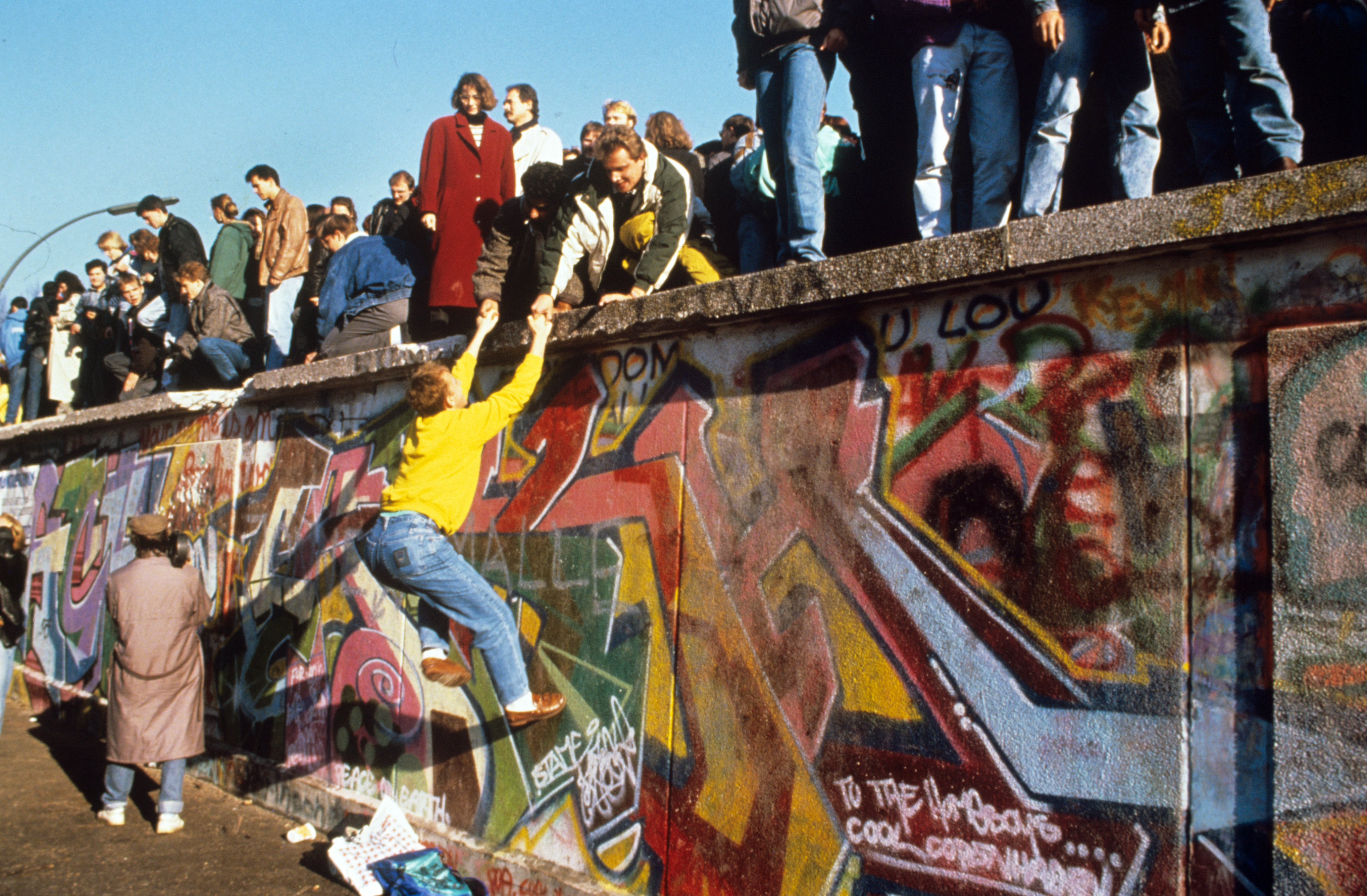 Символ берлинской стены. Берлинская стена 1961-1989. Berlin Wall 1989. Падение Берлинской стены 1989. Солдаты ГДР Берлинская стена 1989.